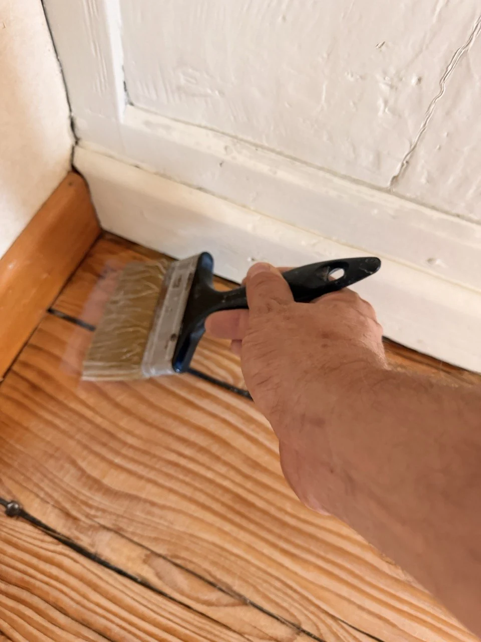 Application au rouleau d'une finition sur un parquet en bois