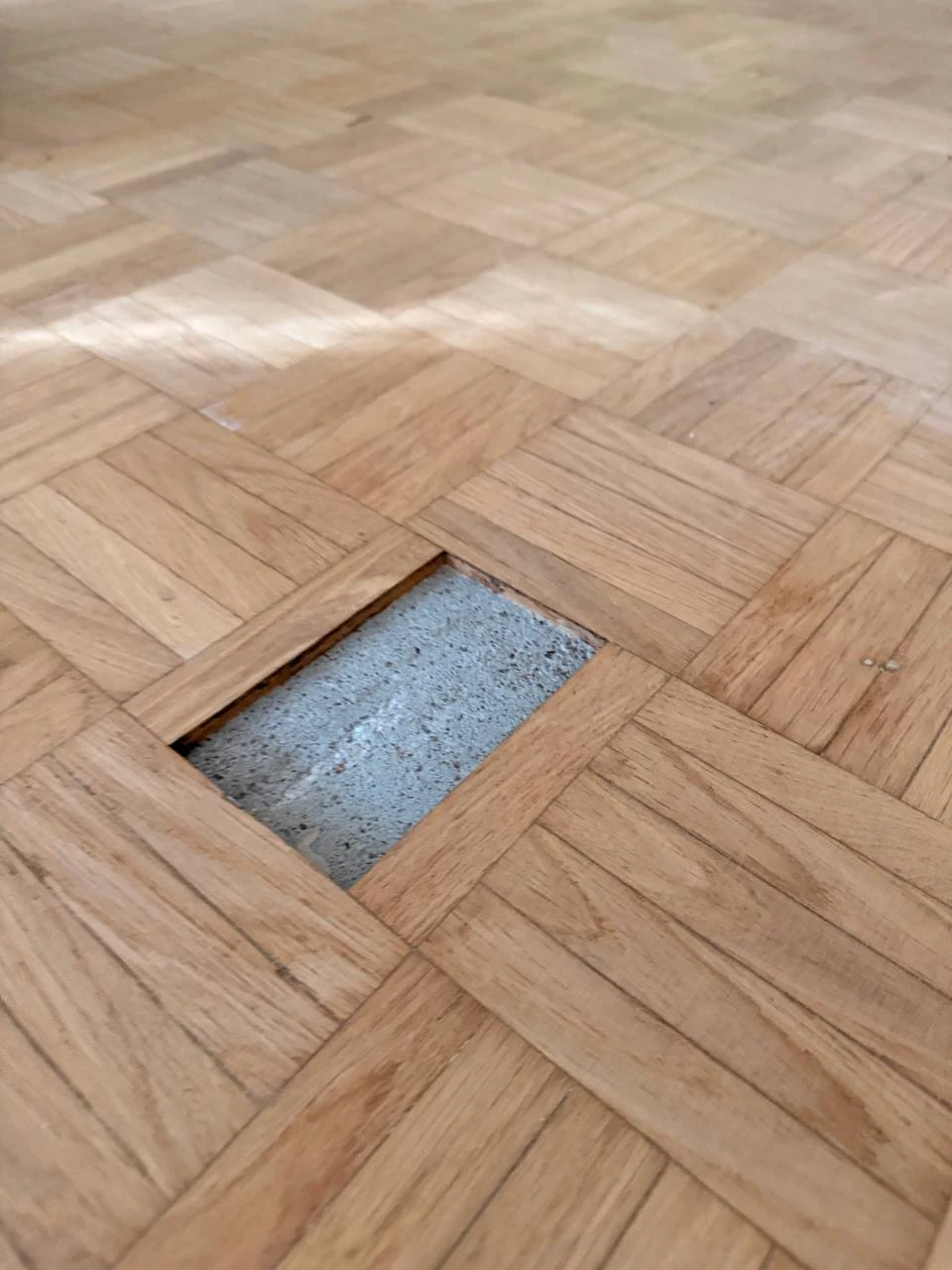 Parquet damier : éléments déposés laissant voir la dalle béton