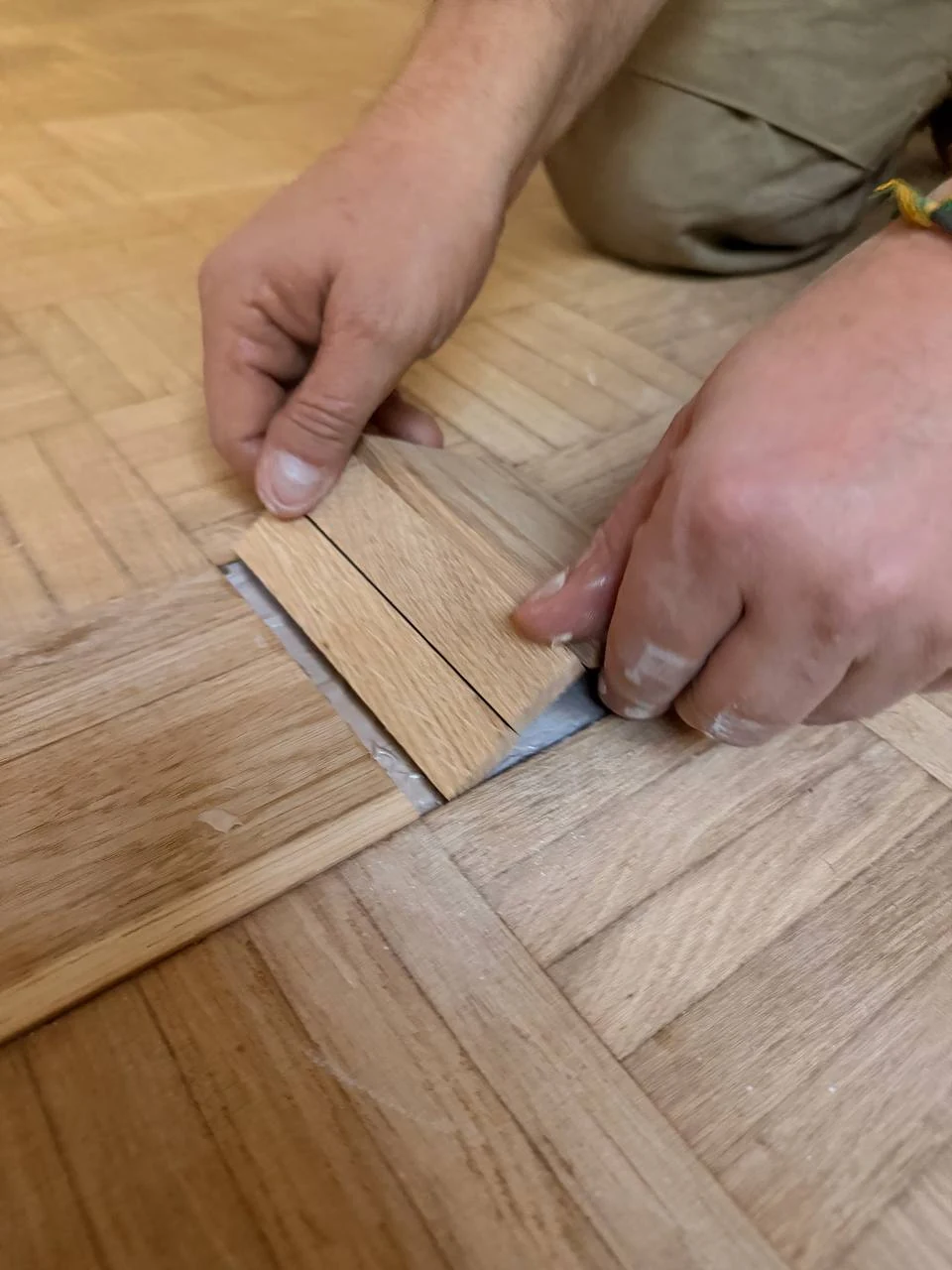 Repose des éléments du parquet damier à la colle