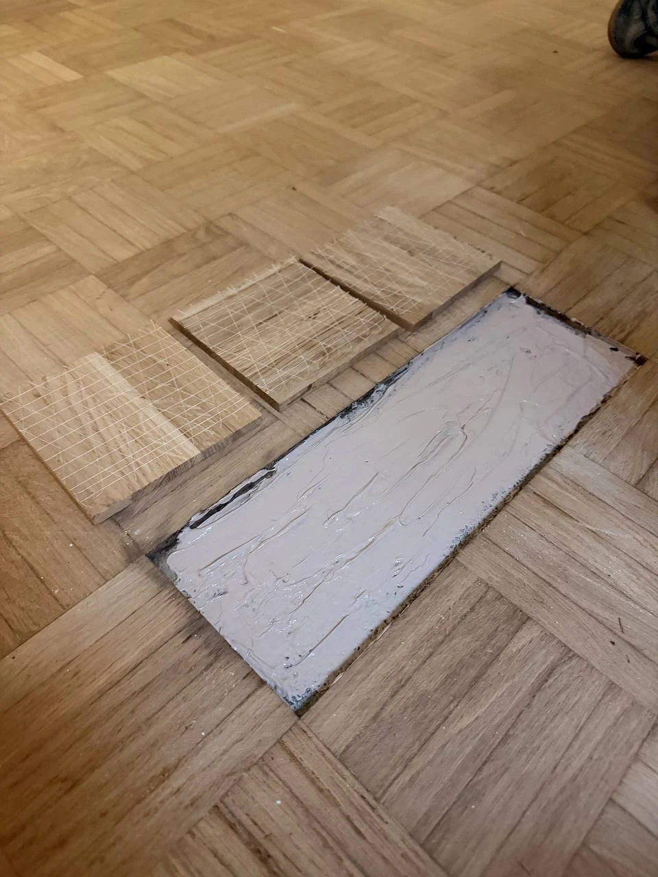 Envers des éléments de parquet damier : trame en fibre de verre