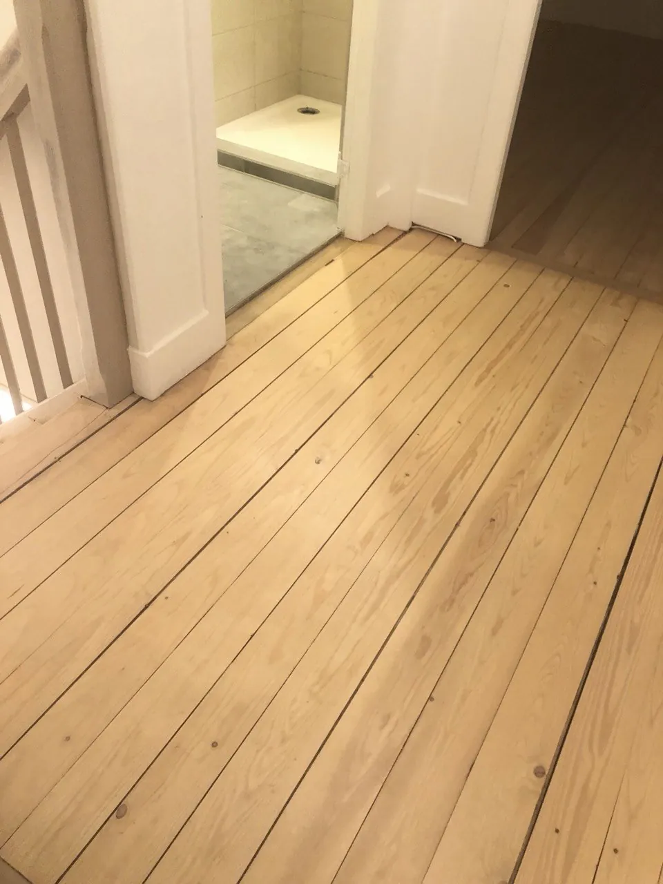 Ponçage de parquet à Wittenheim — Palier : parquet clair, plinthes et portes repeintes.