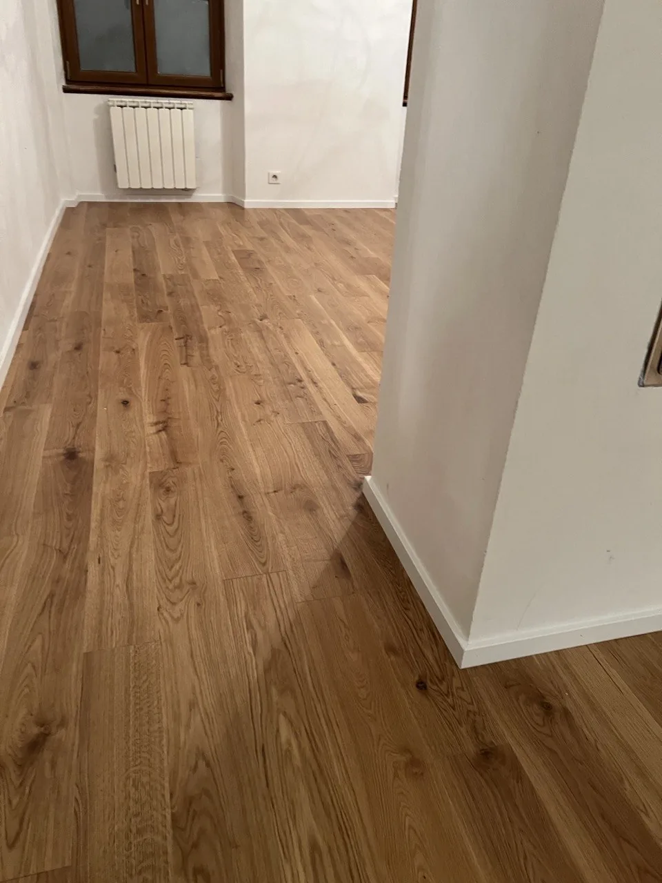 Parquet en chêne dans une pièce, lumière rasante sur le bois