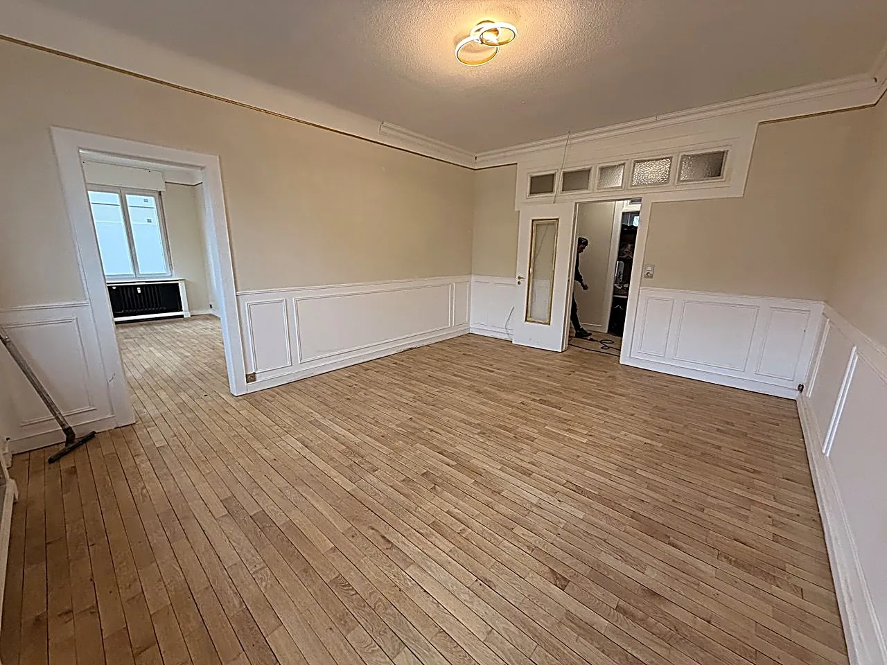 Parquet en bois clair dans un appartement ancien, avec moulures et soubassements