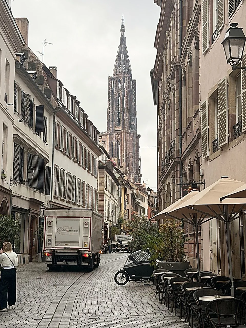 Rue pavée de Strasbourg avec la cathédrale en arrière-plan et des immeubles anciens