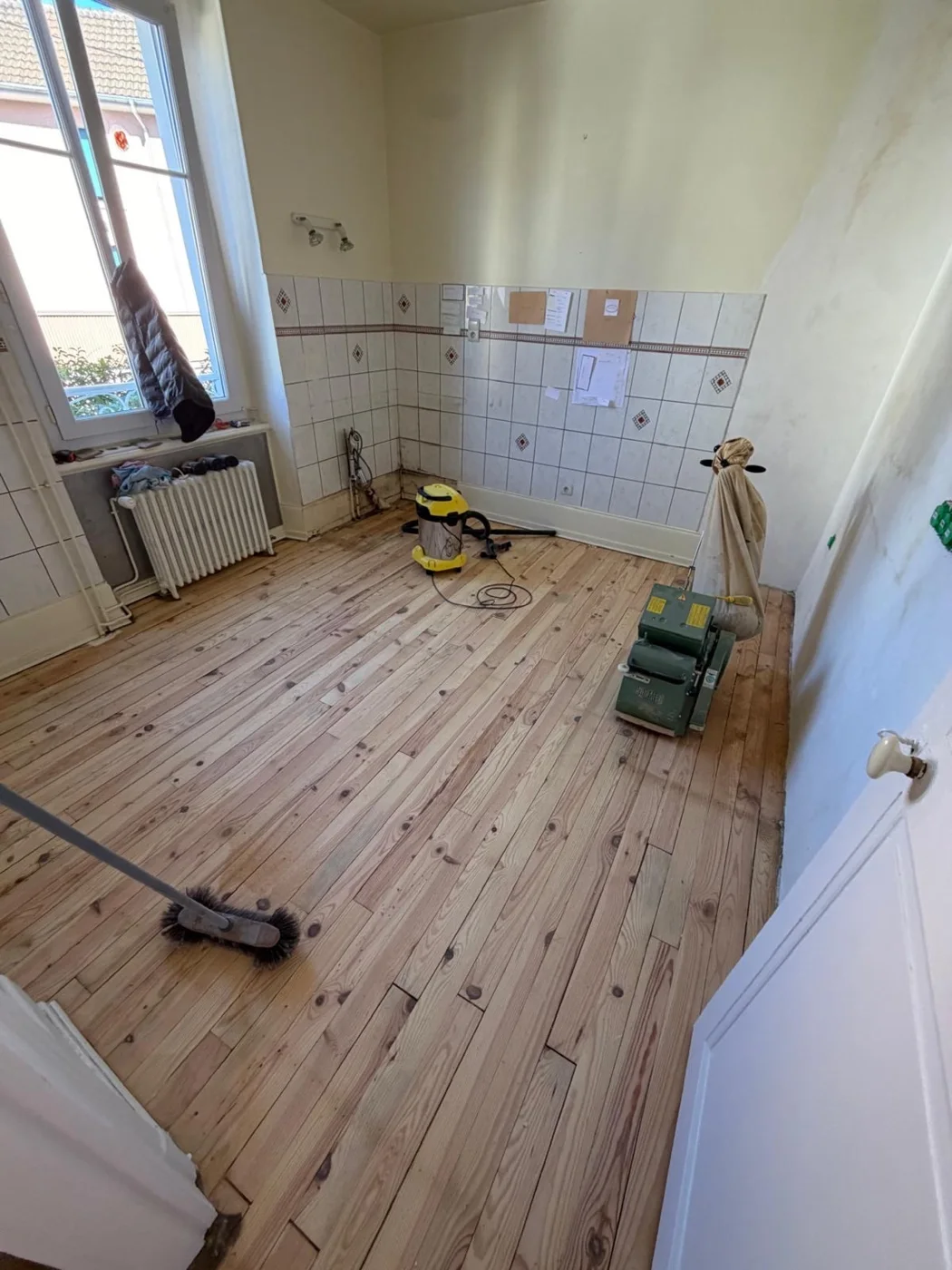 Ponçage du plancher de la cuisine avec le matériel de chantier.