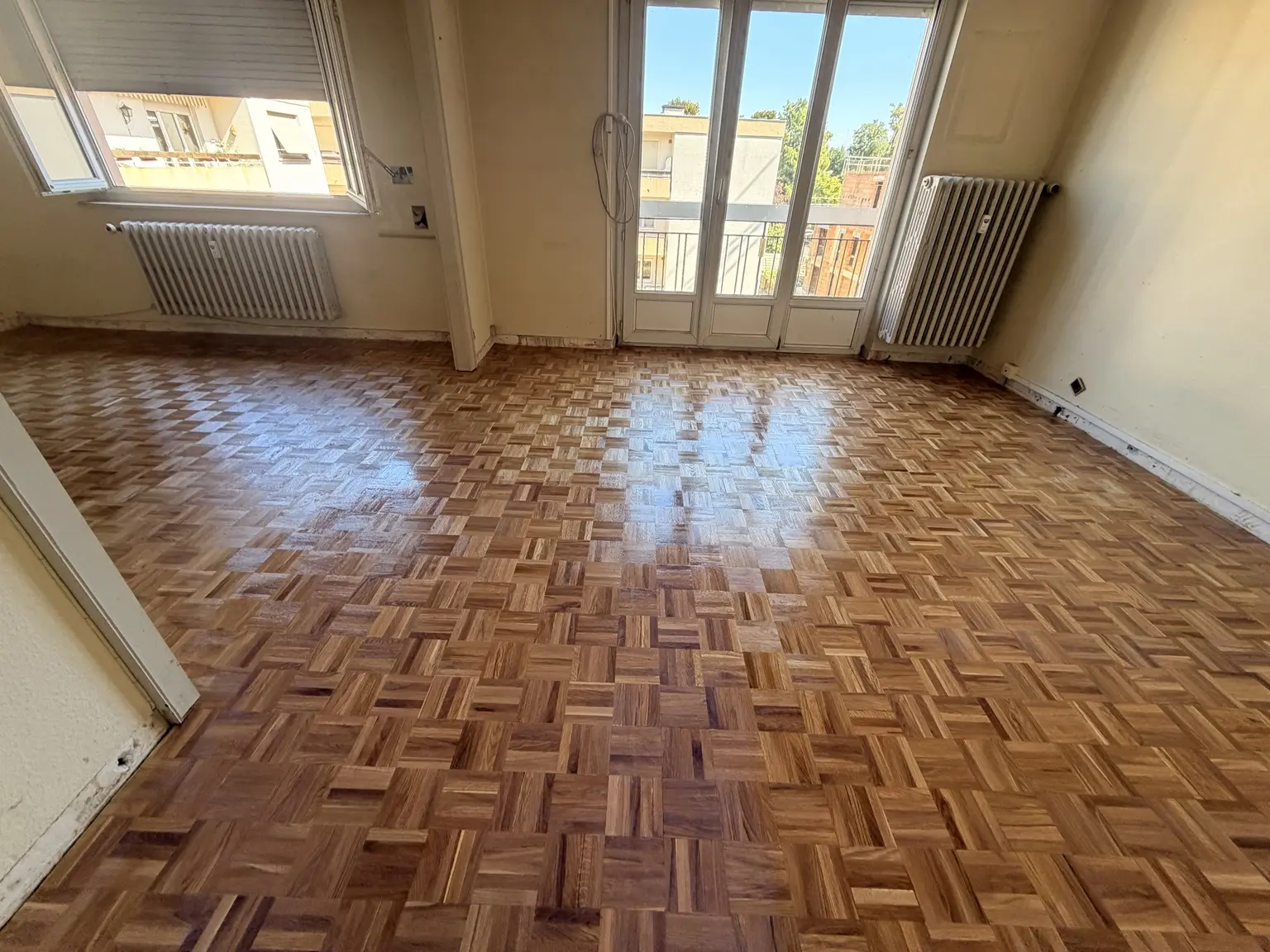 Vue du parquet mosaïque en chêne pendant la vitrification dans l’appartement à Colmar