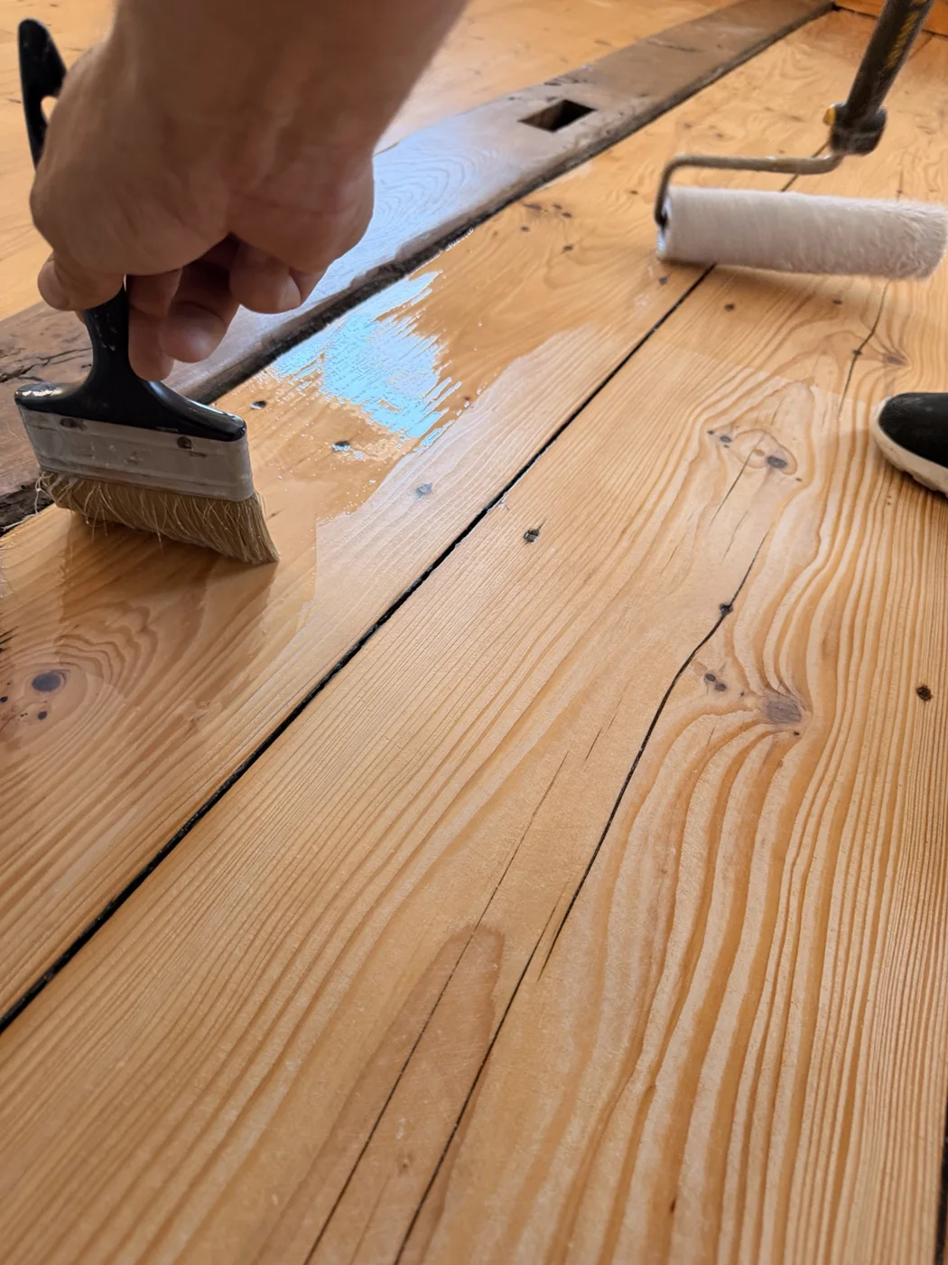Application au rouleau et travail au pinceau sur le parquet.