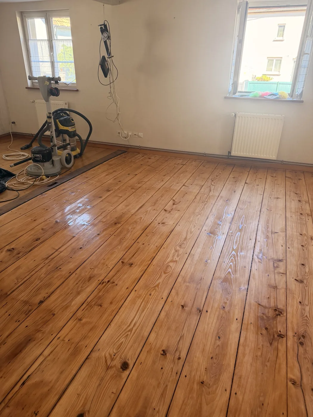 Vue du parquet pendant la mise en finition : le produit est encore en cours de séchage.