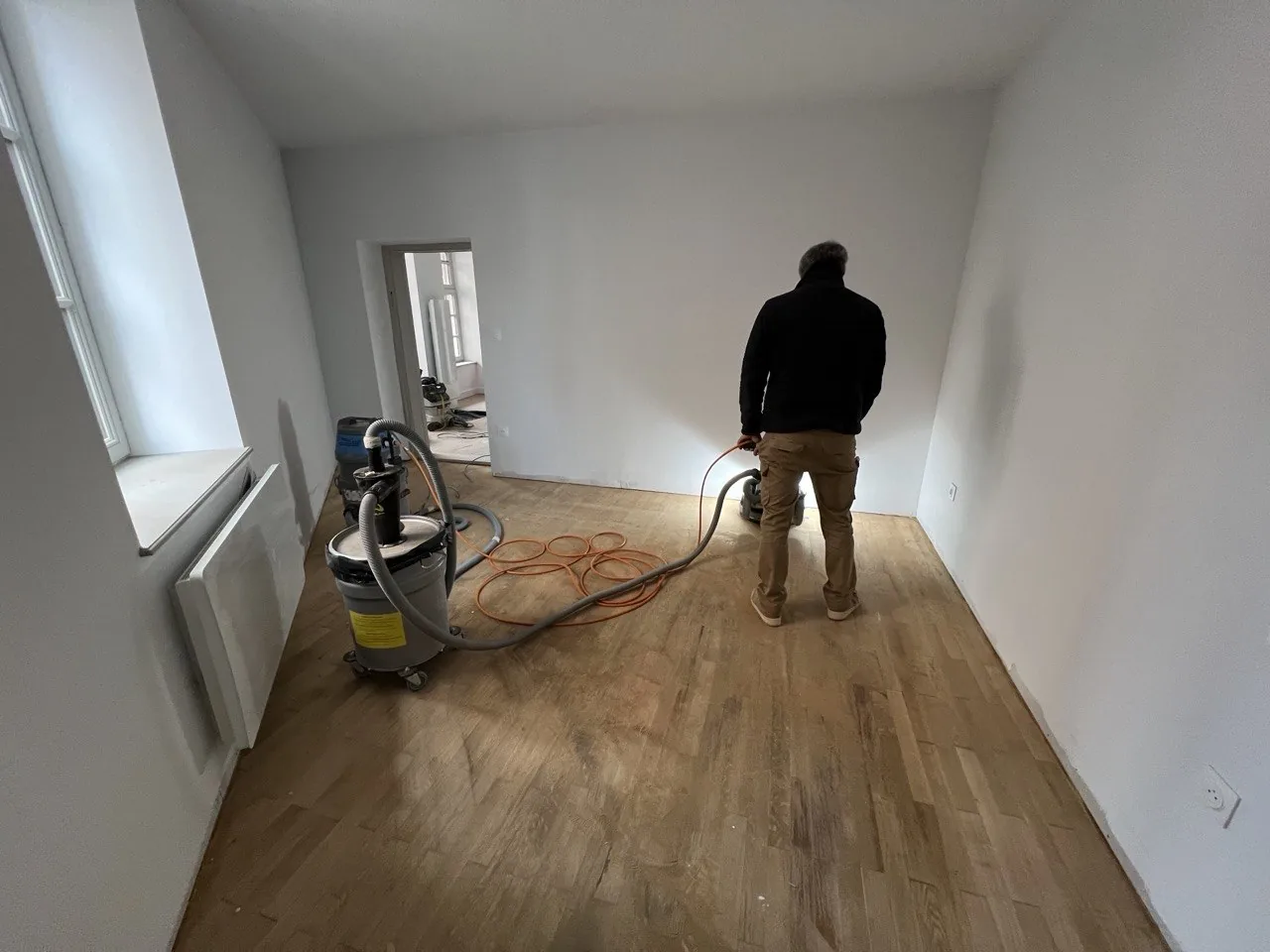 Ponçage d'un parquet en bois lors d'un chantier : remise à nu des lames