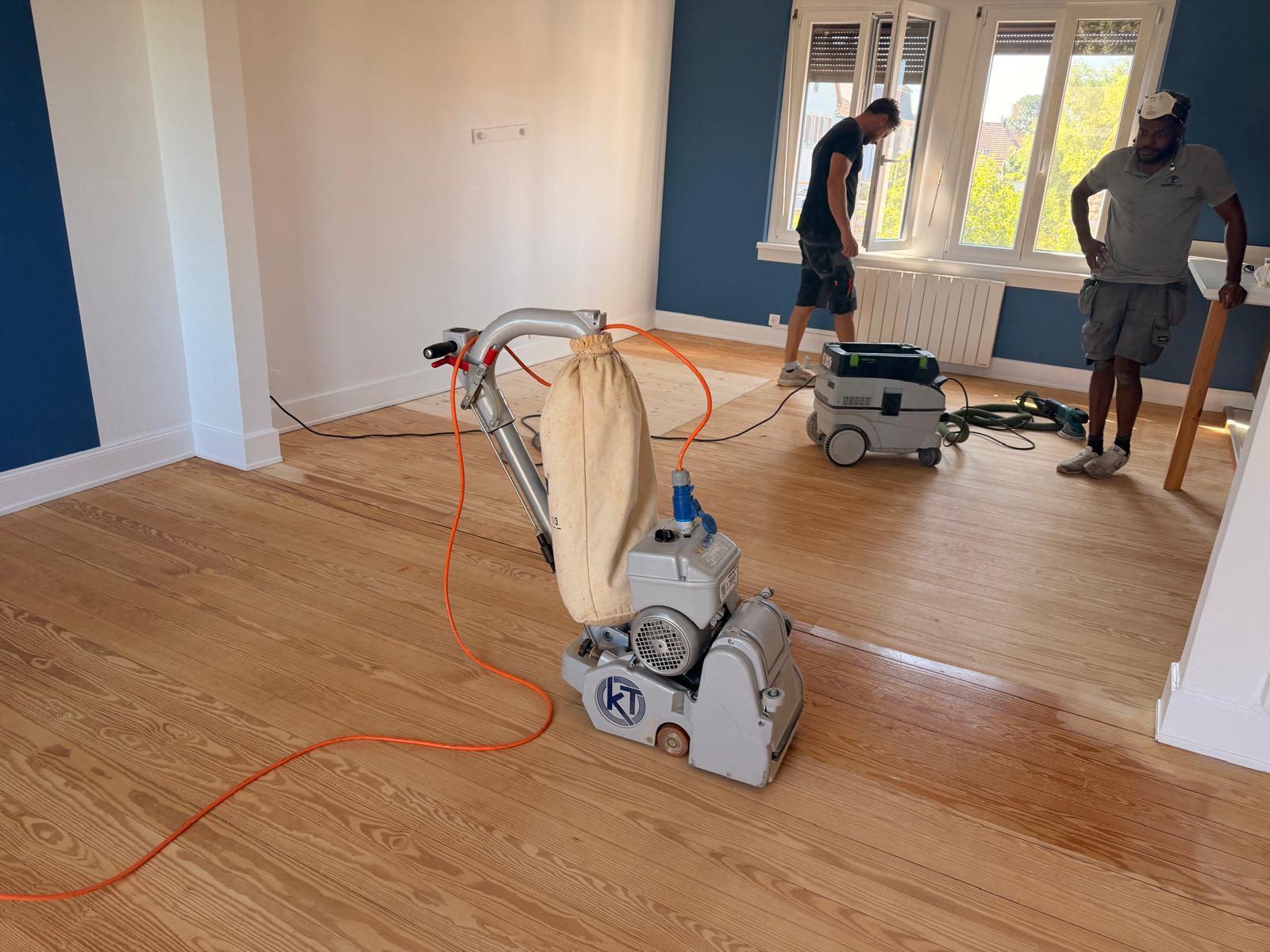 Vue d’ensemble du chantier à Lingolsheim avec les intervenants, la ponceuse et l’aspirateur