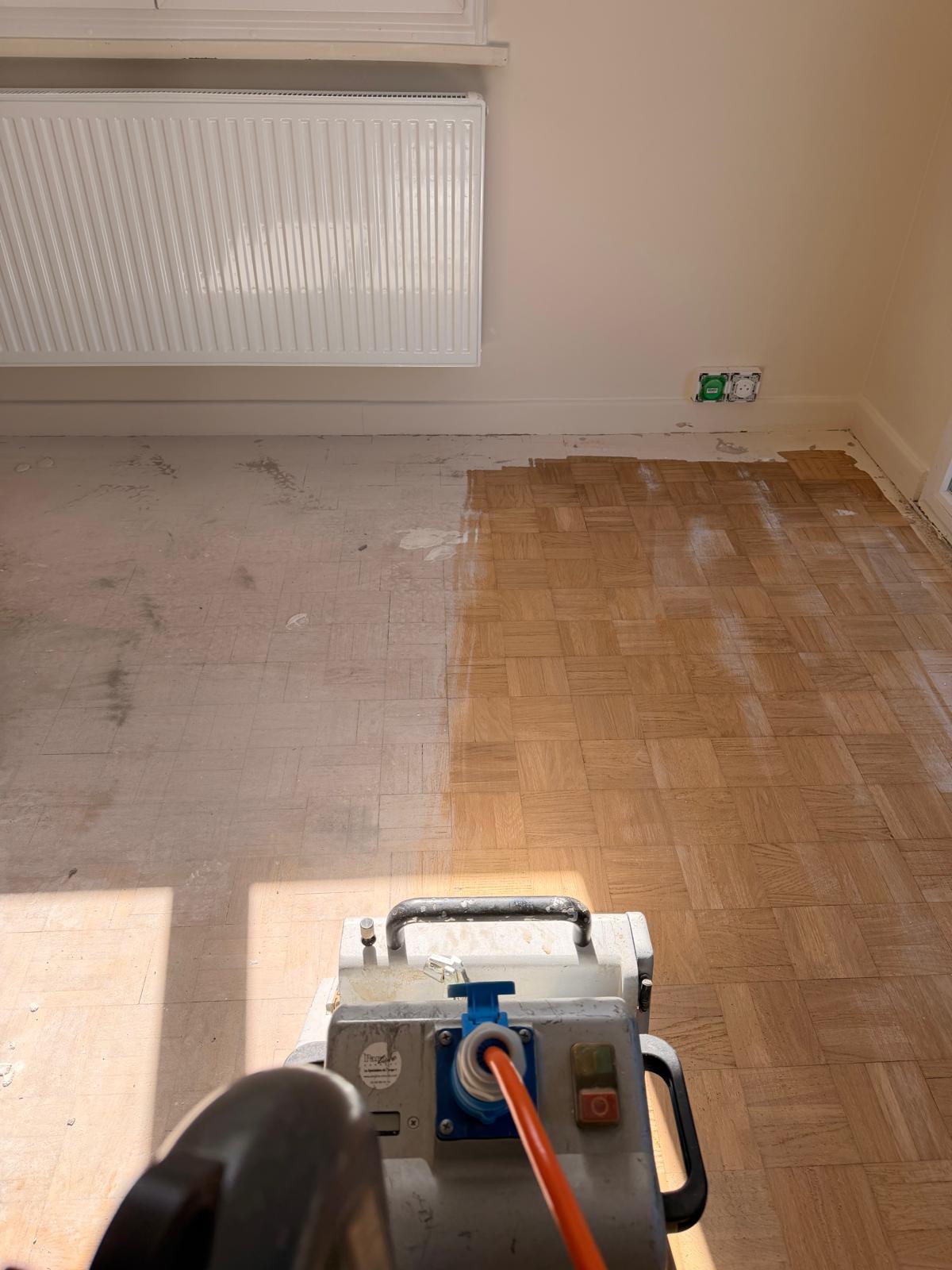 Machine de ponçage devant un parquet en damier en rénovation à Lingolsheim
