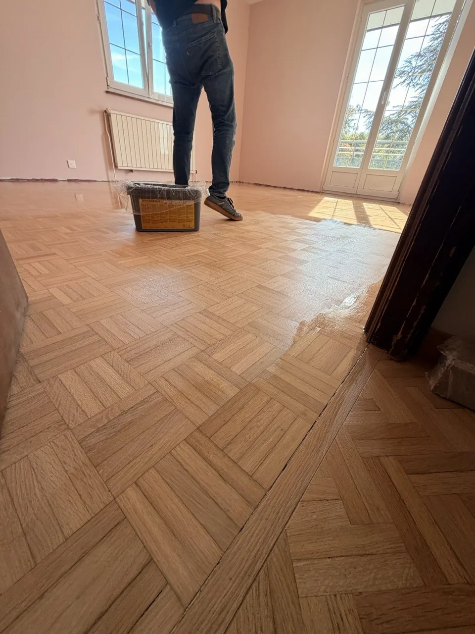 Parquet mosaïque : zone mate déjà prise et zone fraîchement protégée pendant l’application