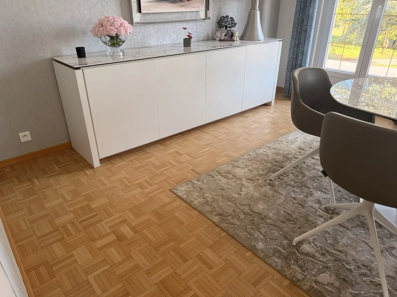 Parquet mosaïque en chêne dans un intérieur contemporain meublé, avec plinthes bois