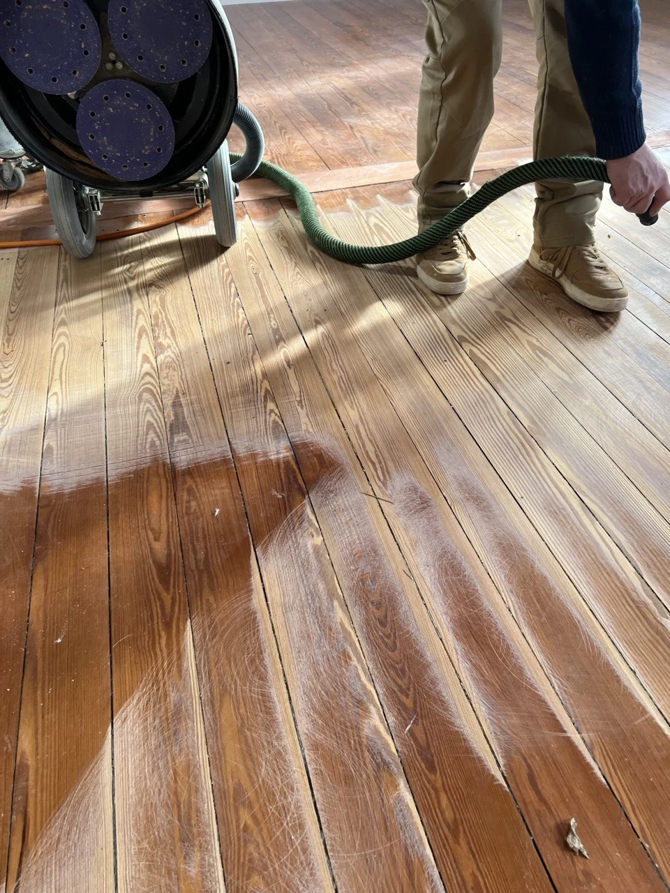 Ponçage de parquet en cours avec aspiration