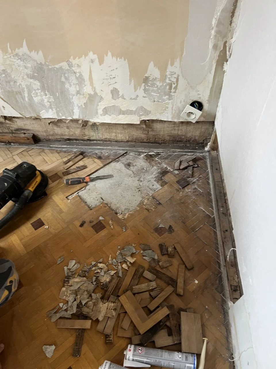 Chantier de réparation : parquet déposé, outils et lames en cours de remplacement